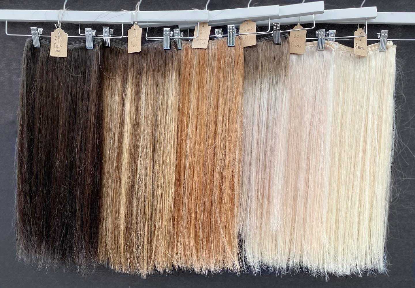 Variety of hair extensions on display, ranging from dark brown to light blonde shades.
